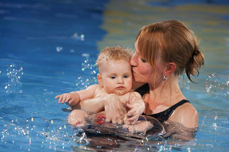 Mutter küsst Kind mit Seifenblasen - Schwimmschule Josefino Dortmund. © Joe Kramer